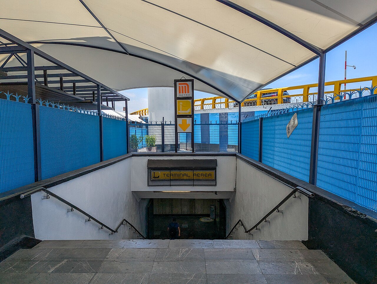 Stairway entrance to the Terminal Aérea station on Line 5 of the Mexico City Metro, under a white canopy